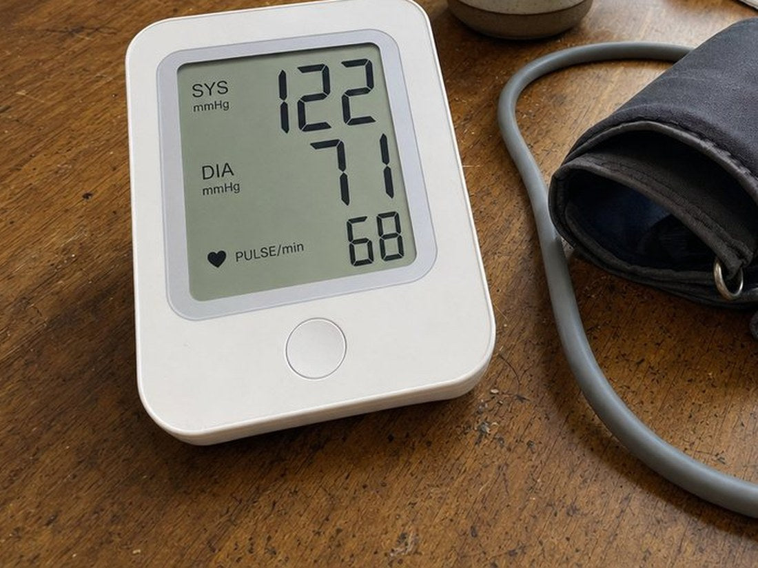 A home blood pressure monitor reading 122 over 71, pulse 68